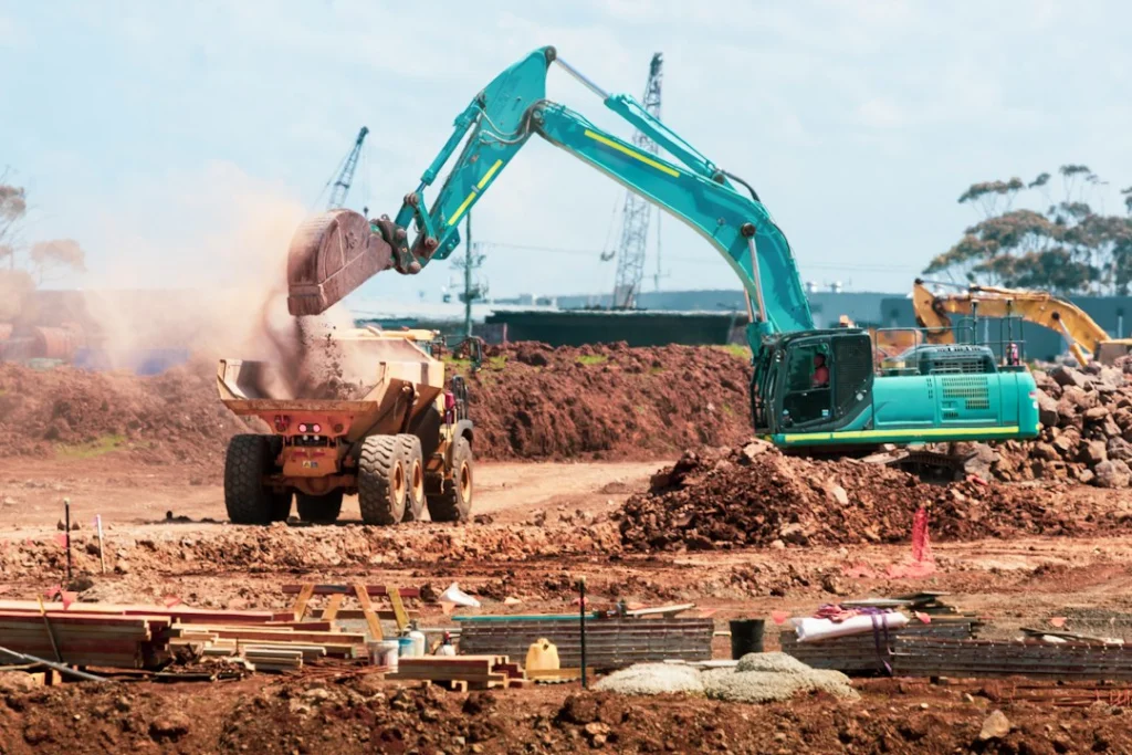 Road construction machinery and earthworks; illustrative stock photograph, not the Jinijini–Sampa project site