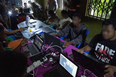 People seated at computers inside a suspected scam centre in Ghana during the October 2026 cybercrime operation
